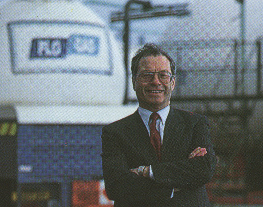 A person standing in from of gas plant and smiling